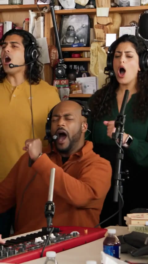 Tiny Desk AI video for group chats: the keyboard player singing with two backup singers Tiny Desk AI video for group chats: the keyboard player singing with two backup singers
